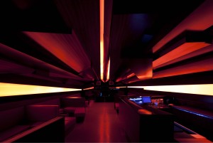 Lounge space perspective toward the DJ desk: red lights